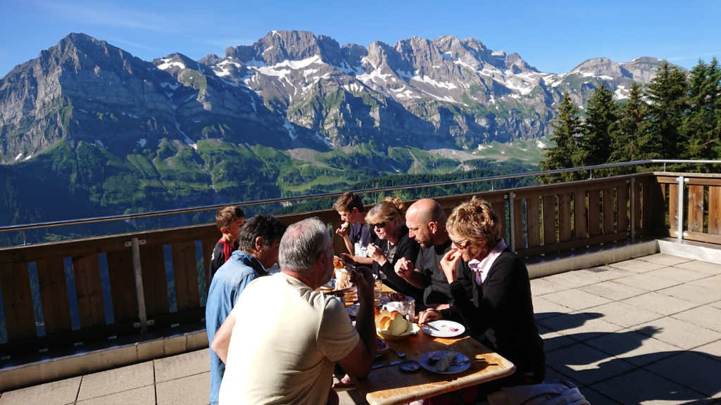 Groupe attablé sur la terrasse du chalet, avec vue sur les montagnes